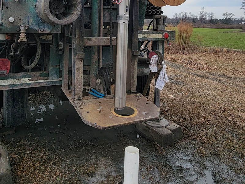 a water pump is being used to pump water into a hole in the ground