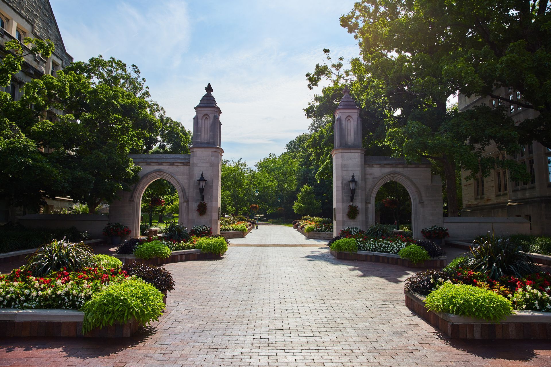 A brick walkway with a stone archway leading to a building