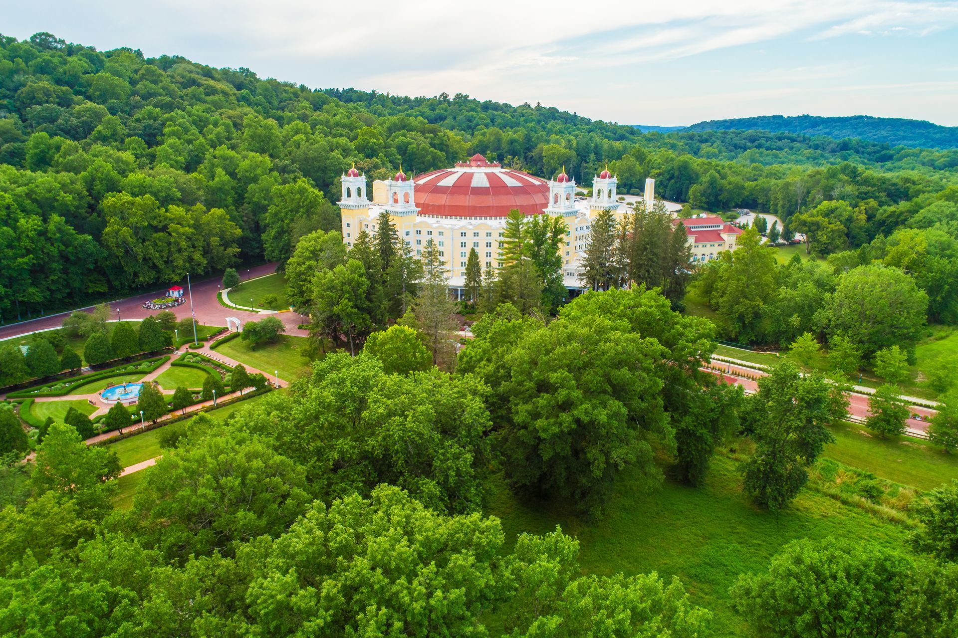 An aerial view of a large white building surrounded by trees.