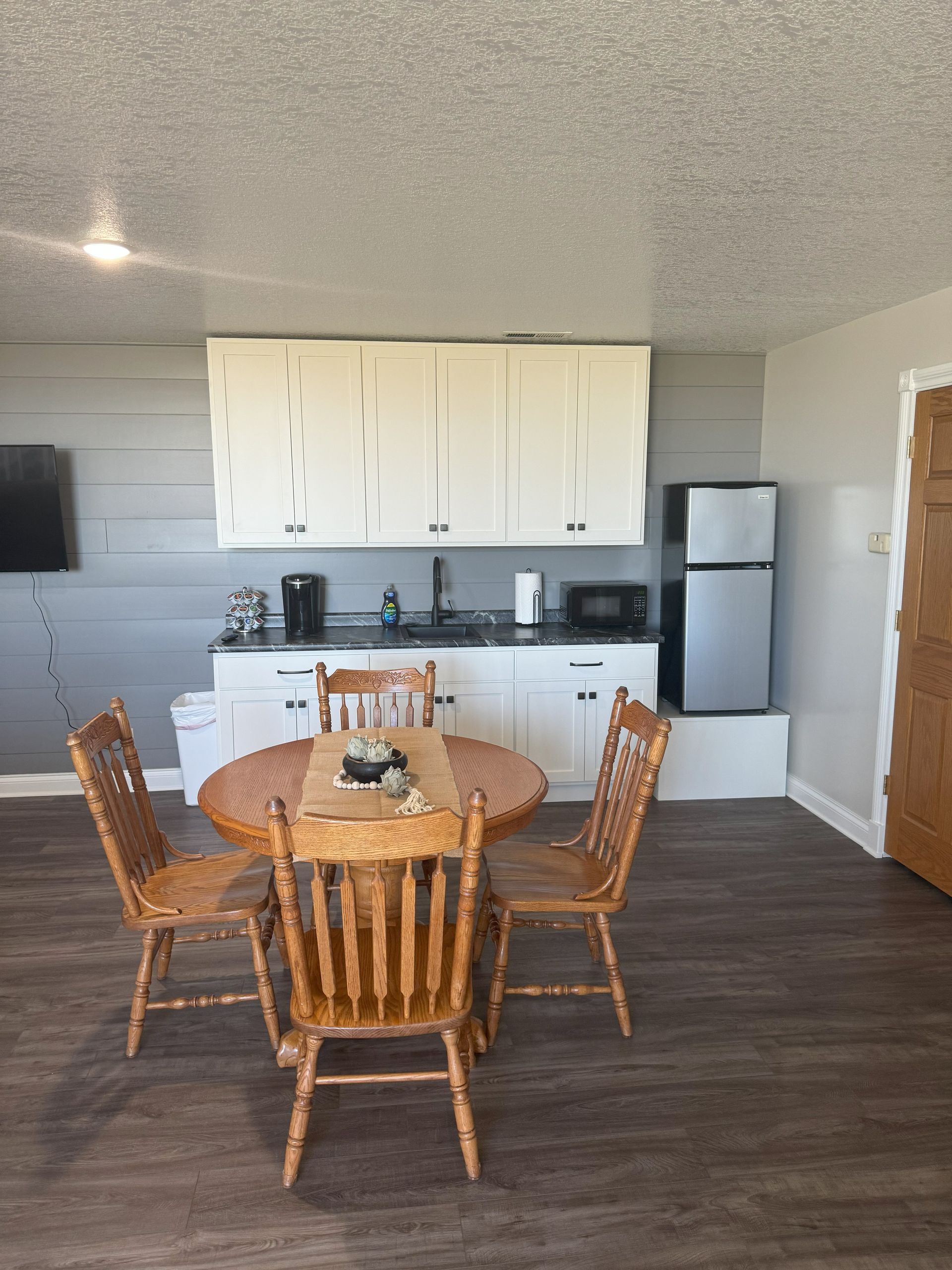 A kitchen with a table and chairs and a refrigerator.