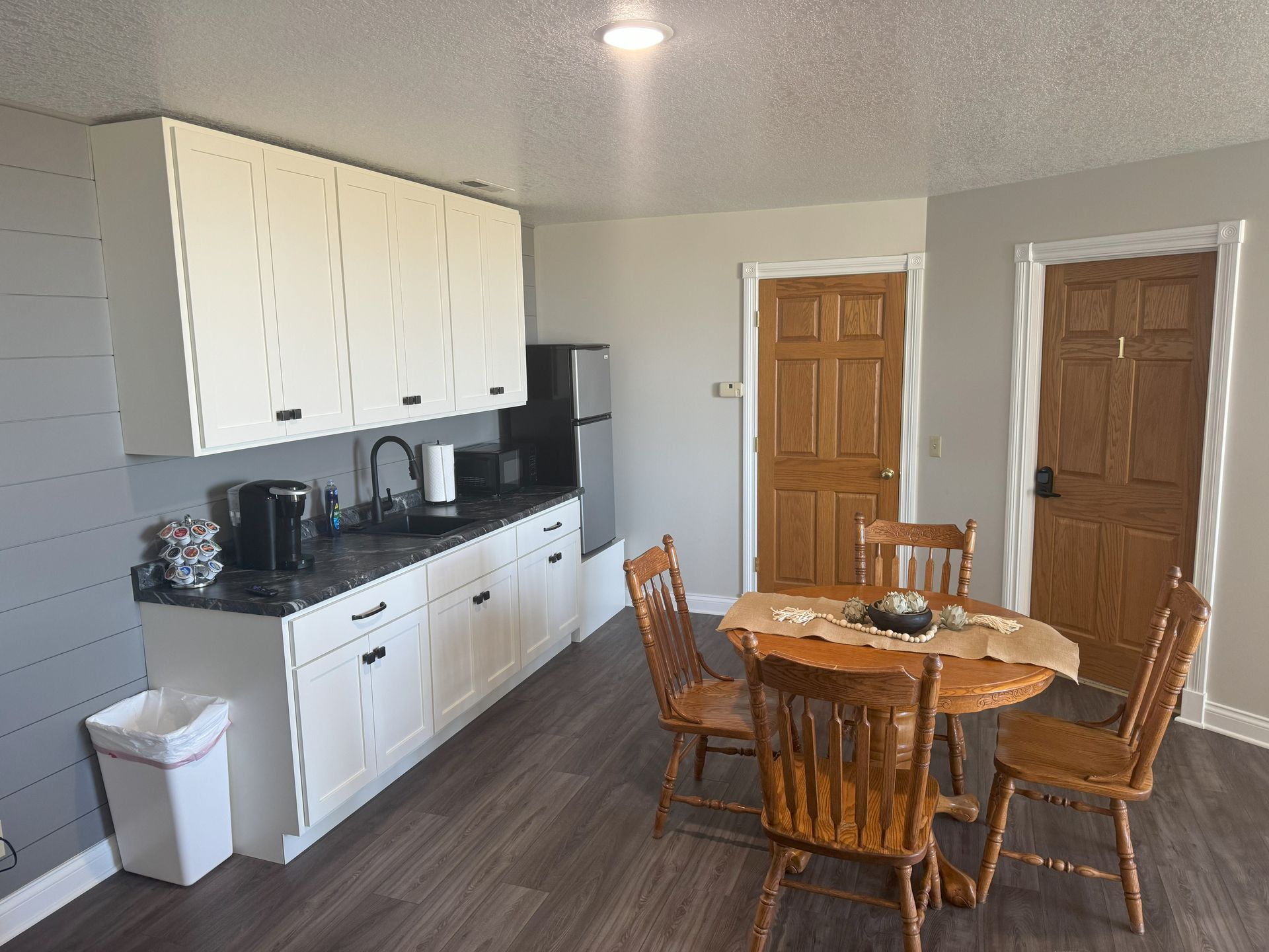 A kitchen with a table and chairs and a refrigerator.