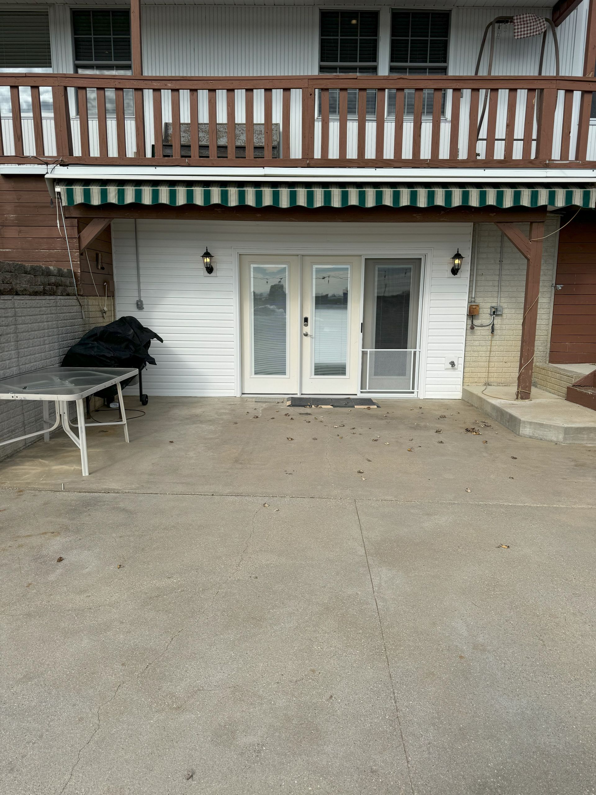 A white house with a green and white awning