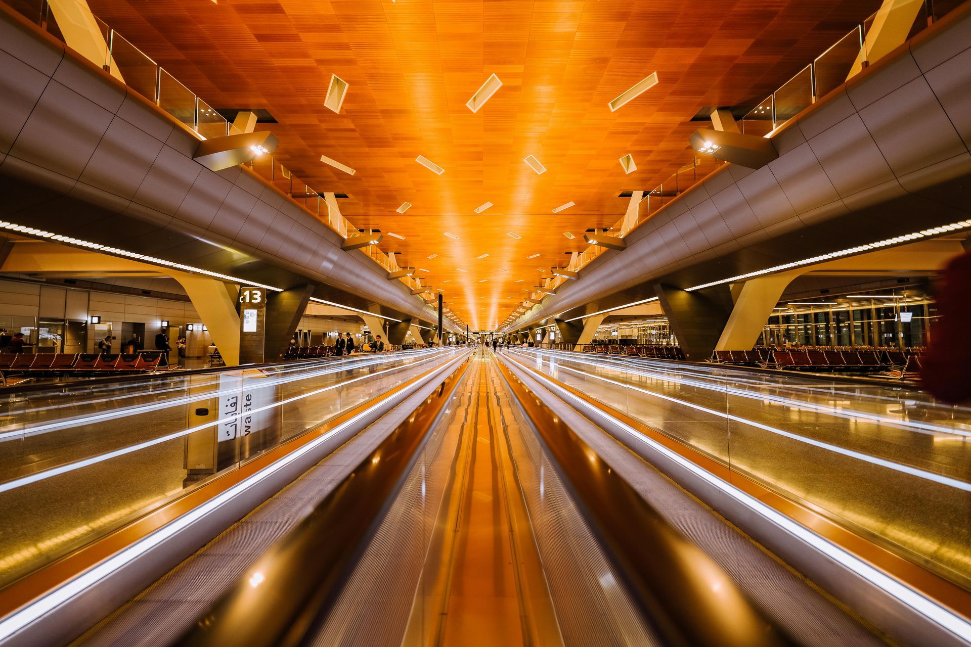 A long exposure photo of a train station with a wooden ceiling