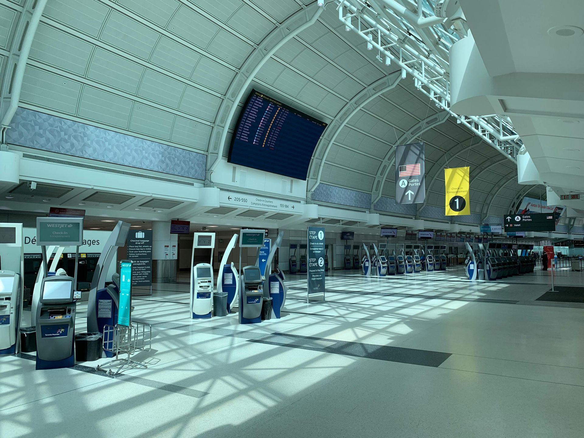 A large empty airport with a sign that says ' departures ' on it