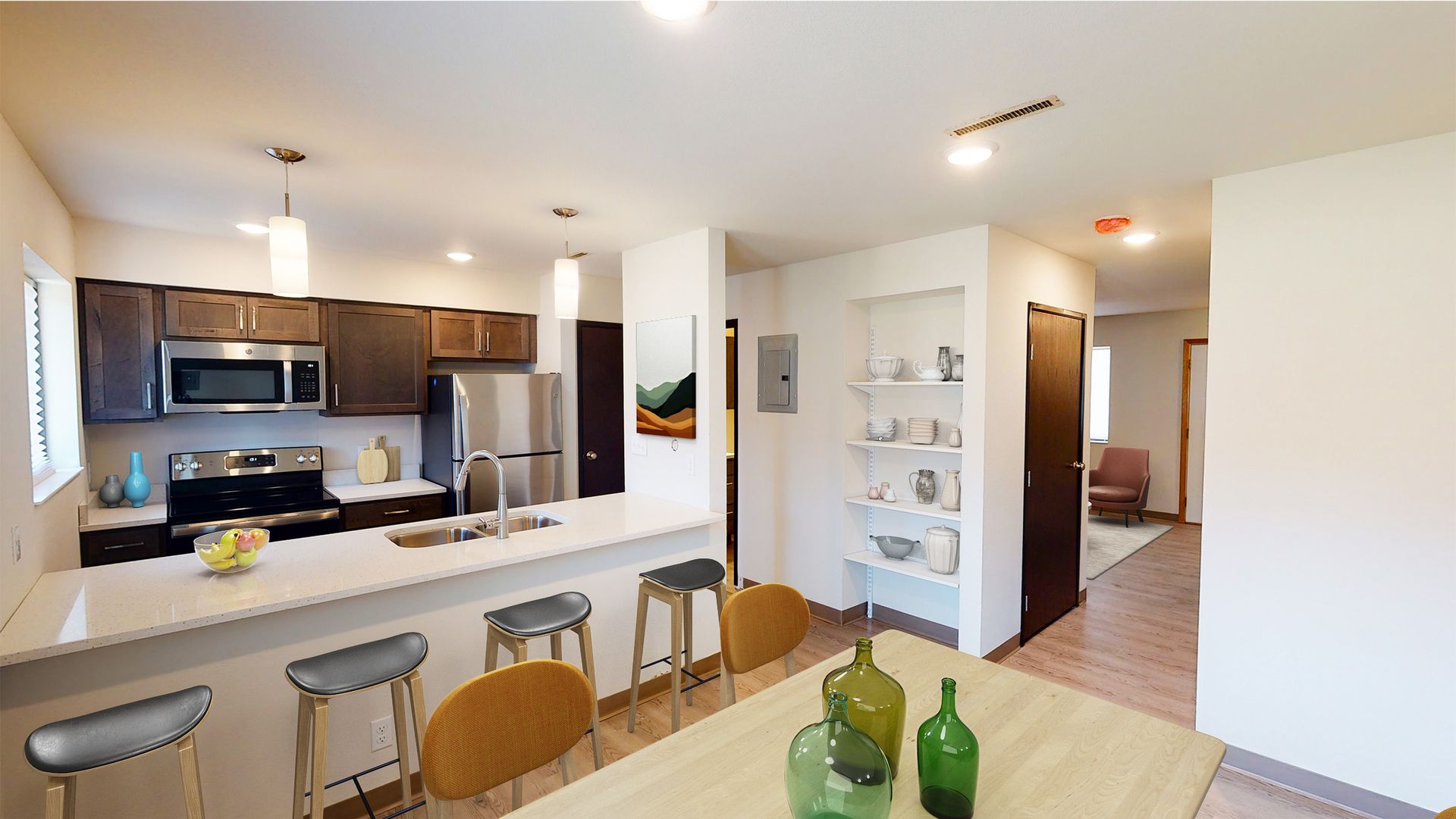 An updated kitchen and dining room area with a countertop bar and built-in shelving.