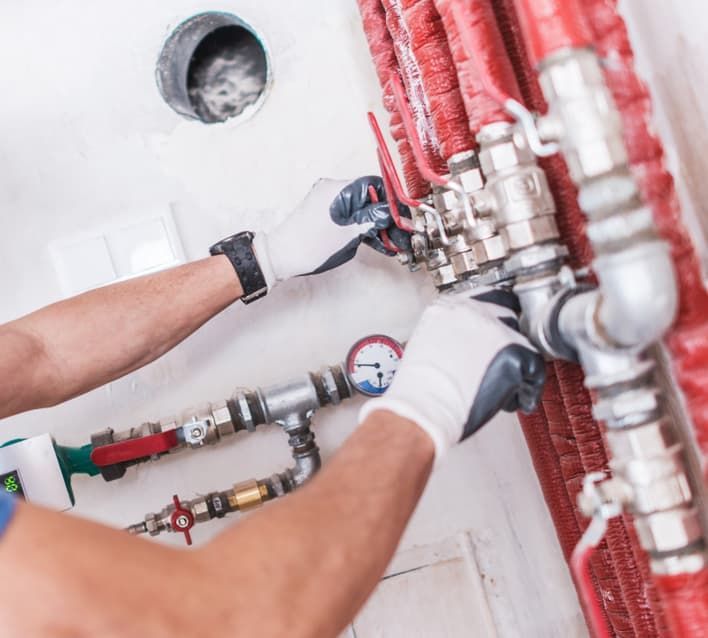 A Man Without A Shirt Is Working On A Water Pipe — JSB Plumbing & Gas In South Grafton, NSW