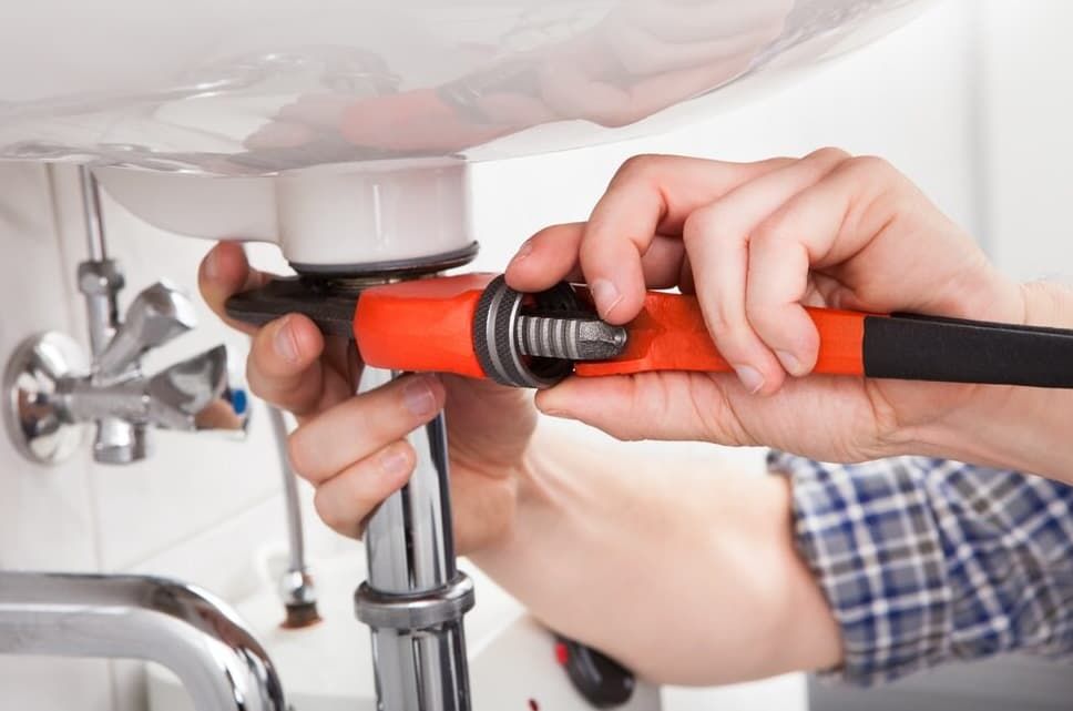 A Plumber Is Fixing A Sink With A Wrench — JSB Plumbing & Gas In South Grafton, NSW
