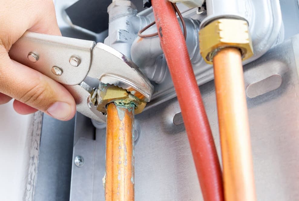 A Person Is Fixing A Pipe With A Wrench — JSB Plumbing & Gas In South Grafton, NSW