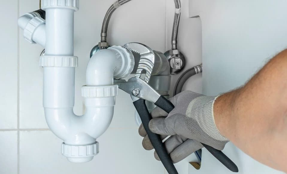 A Plumber Is Fixing A Sink Pipe With A Wrench — JSB Plumbing & Gas In South Grafton, NSW