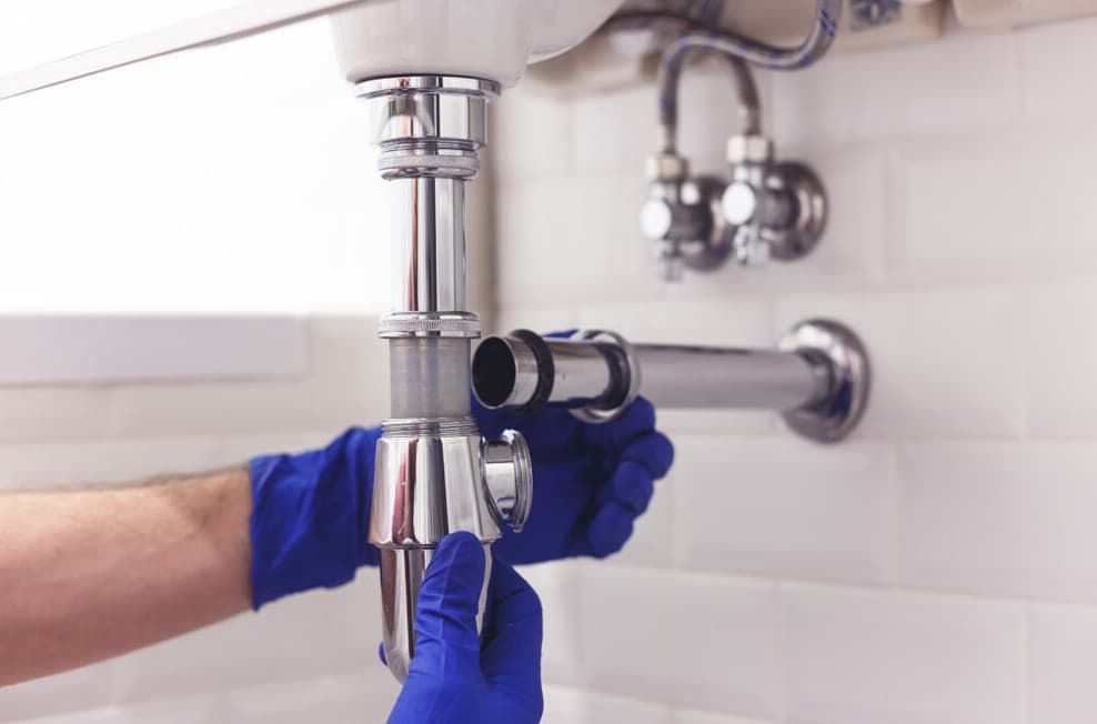 A Plumber Is Fixing A Sink Pipe In A Bathroom — JSB Plumbing & Gas In South Grafton, NSW