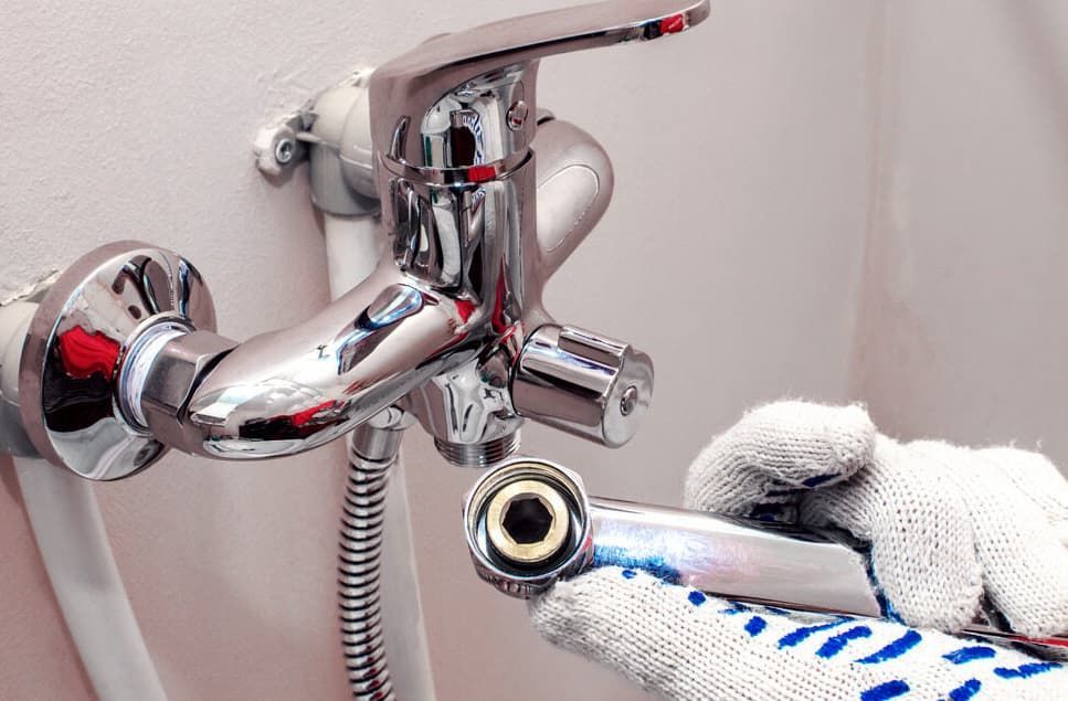 A Person Is Fixing A Bathroom Faucet With A Wrench — JSB Plumbing & Gas In South Grafton, NSW