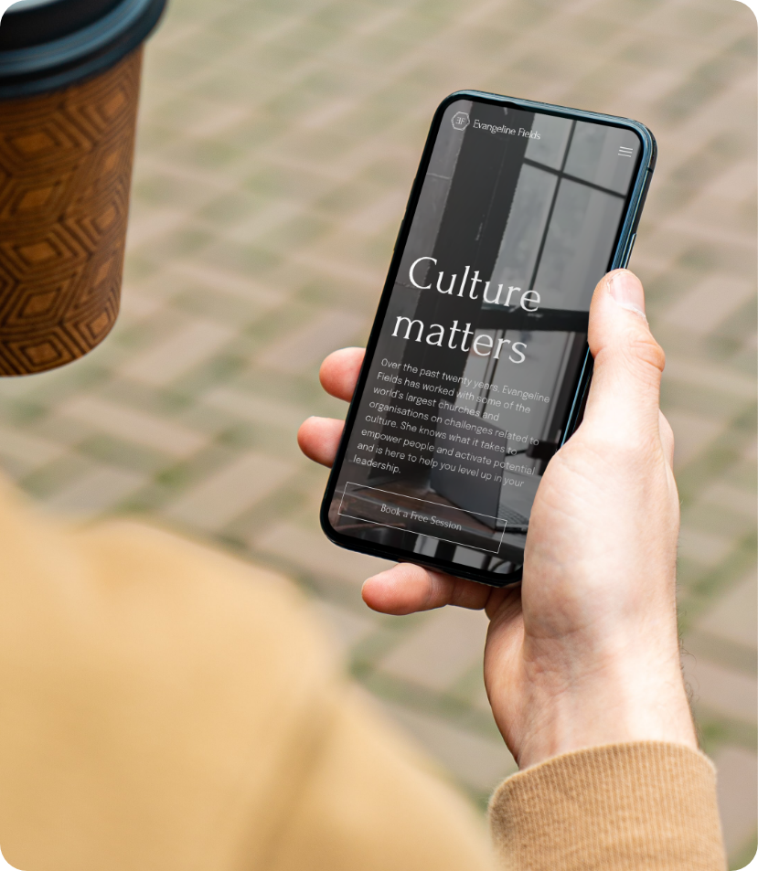 Evangeline Fields website template displayed on mobile as man holds cellphone