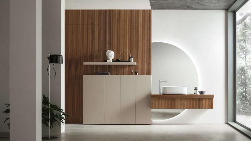 Un bagno con lavandino, armadietti e una grande finestra.