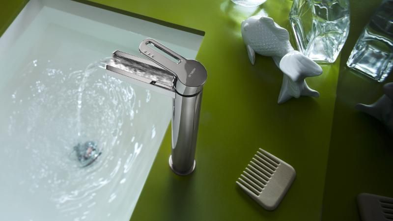 Un lavandino del bagno con rubinetto e pettine sul ripiano.