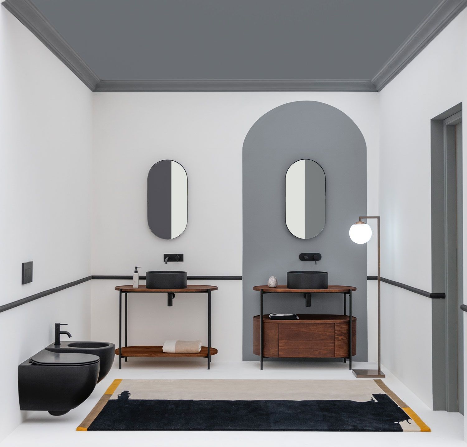 Un bagno con due wc un lavandino e uno specchio