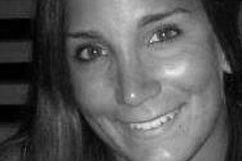 Smiling woman with long hair, looking at the camera. Black and white photo.