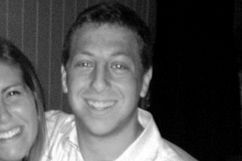 Smiling man in white shirt, black and white photo.