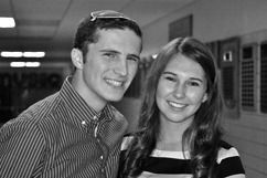 Young man with kippah and woman smile together in a hallway. Black and white photo.