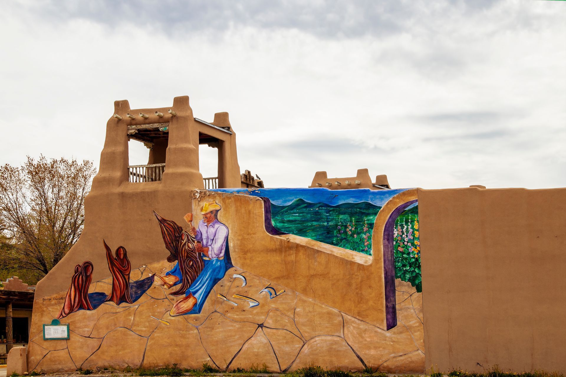 A mural on the side of a building shows a man holding an eagle