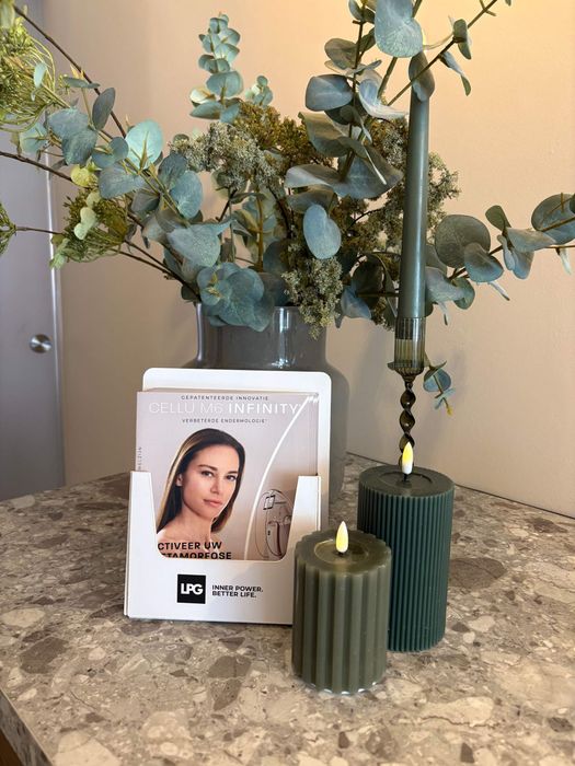 Een vrouw in een witte jas gebruikt een machine op de arm van een patiƫnt.