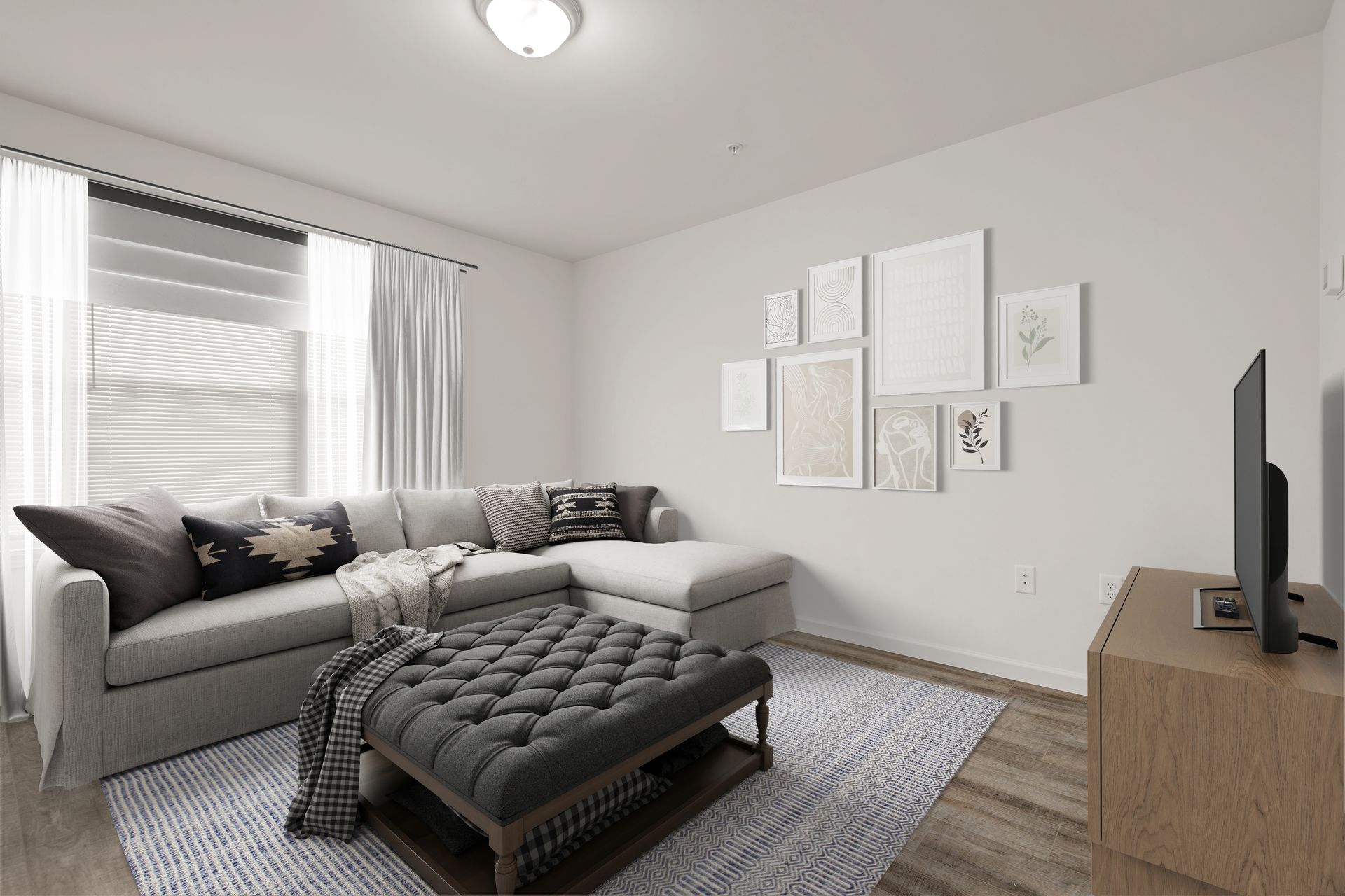 A living room with a sectional couch , ottoman , and television.