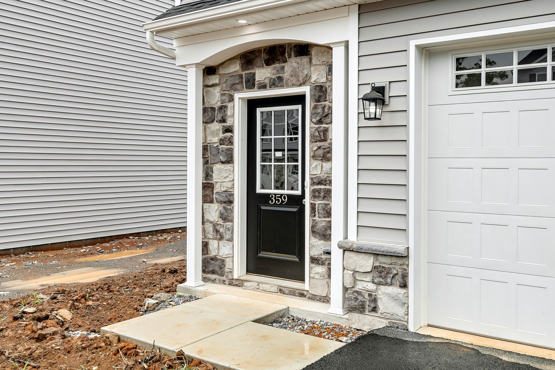 A house with a black door and a white garage door.