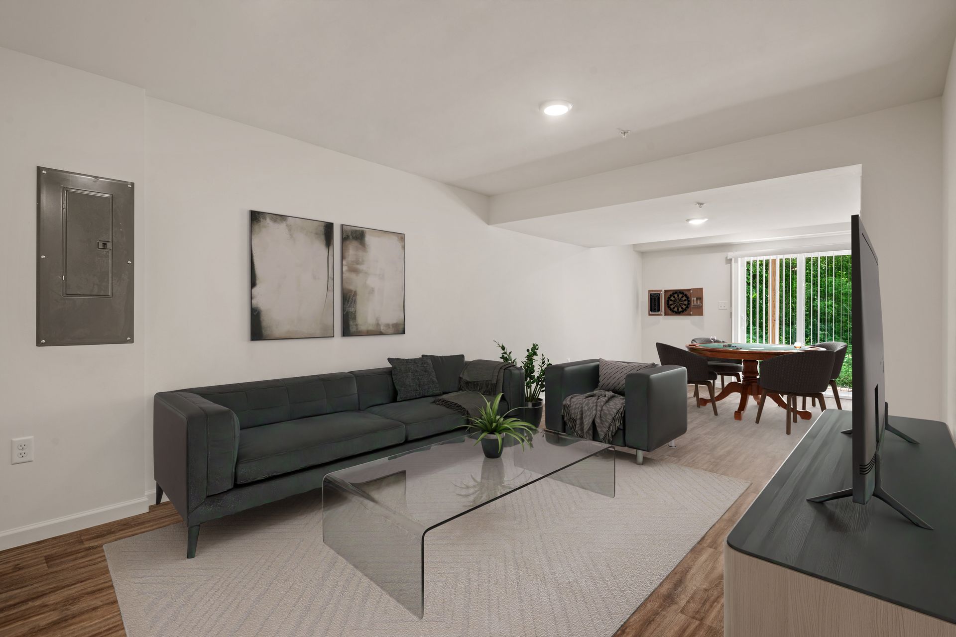 A living room with a couch , chair , coffee table and television.