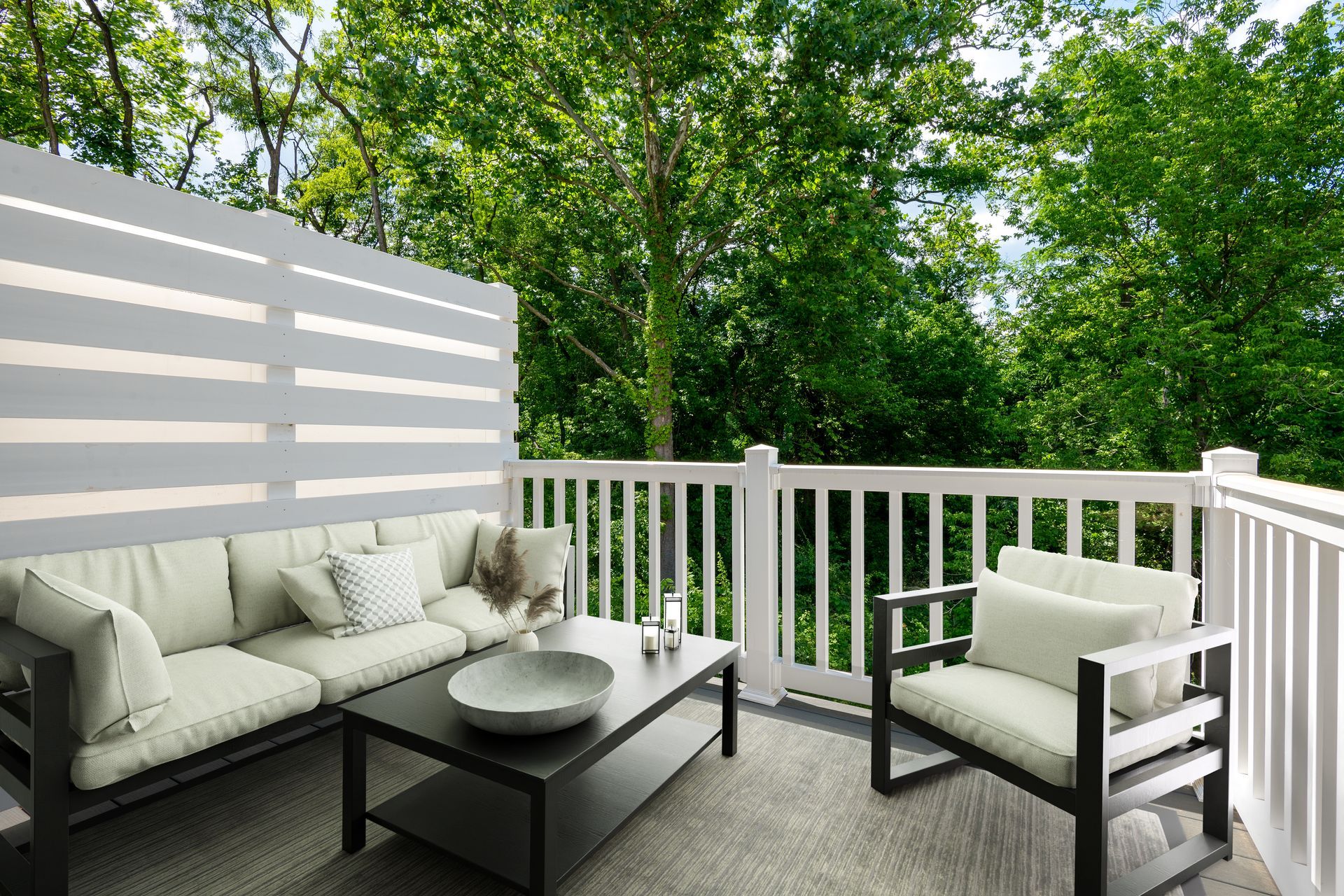 A balcony with a couch , chairs , and a coffee table.