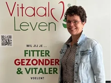 Een vrouw staat voor een bord met de tekst vitaal leven