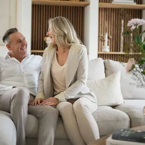 Een man en een vrouw zitten op een bank in de woonkamer.