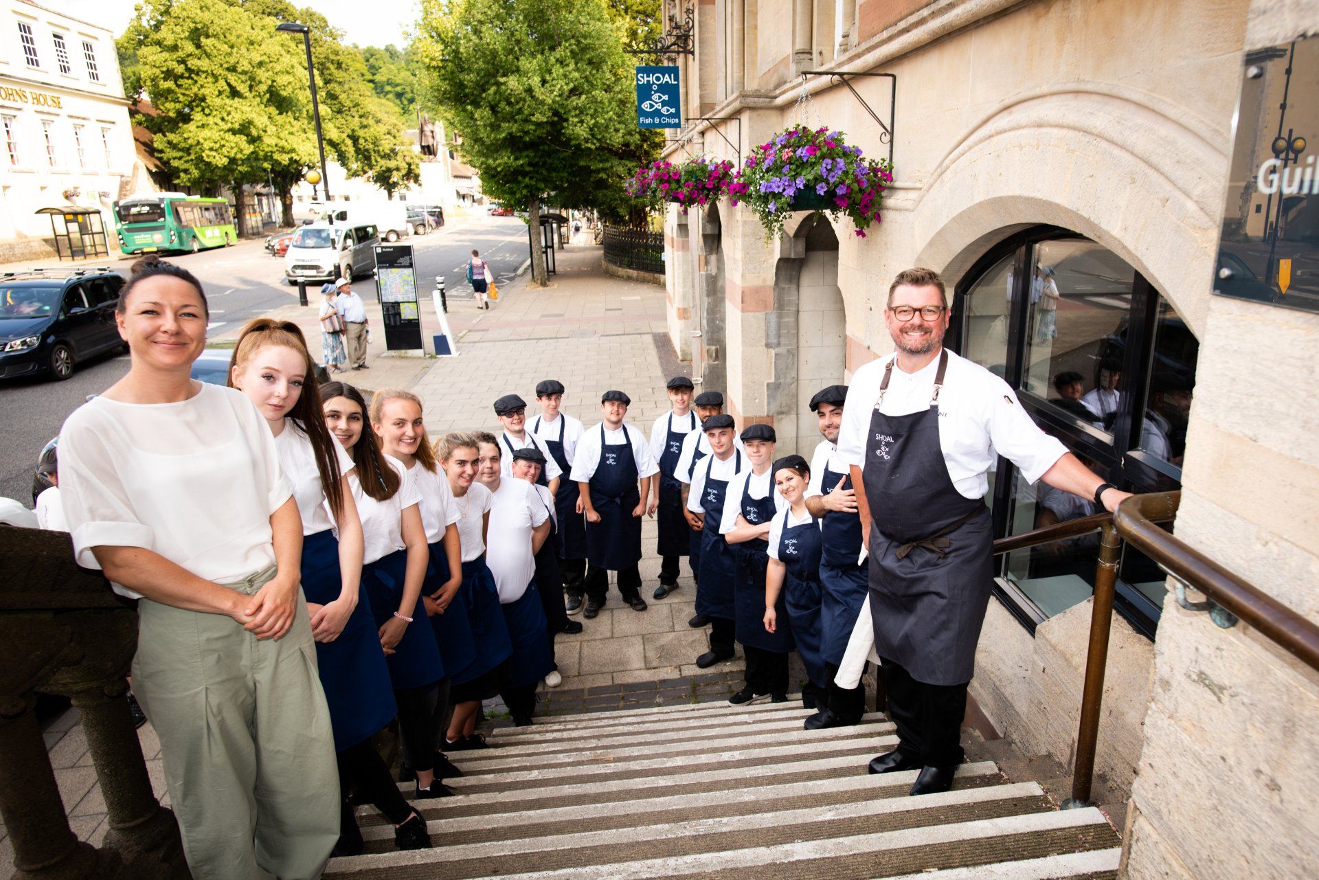 A group of people are standing on a set of stairs in front of a building.