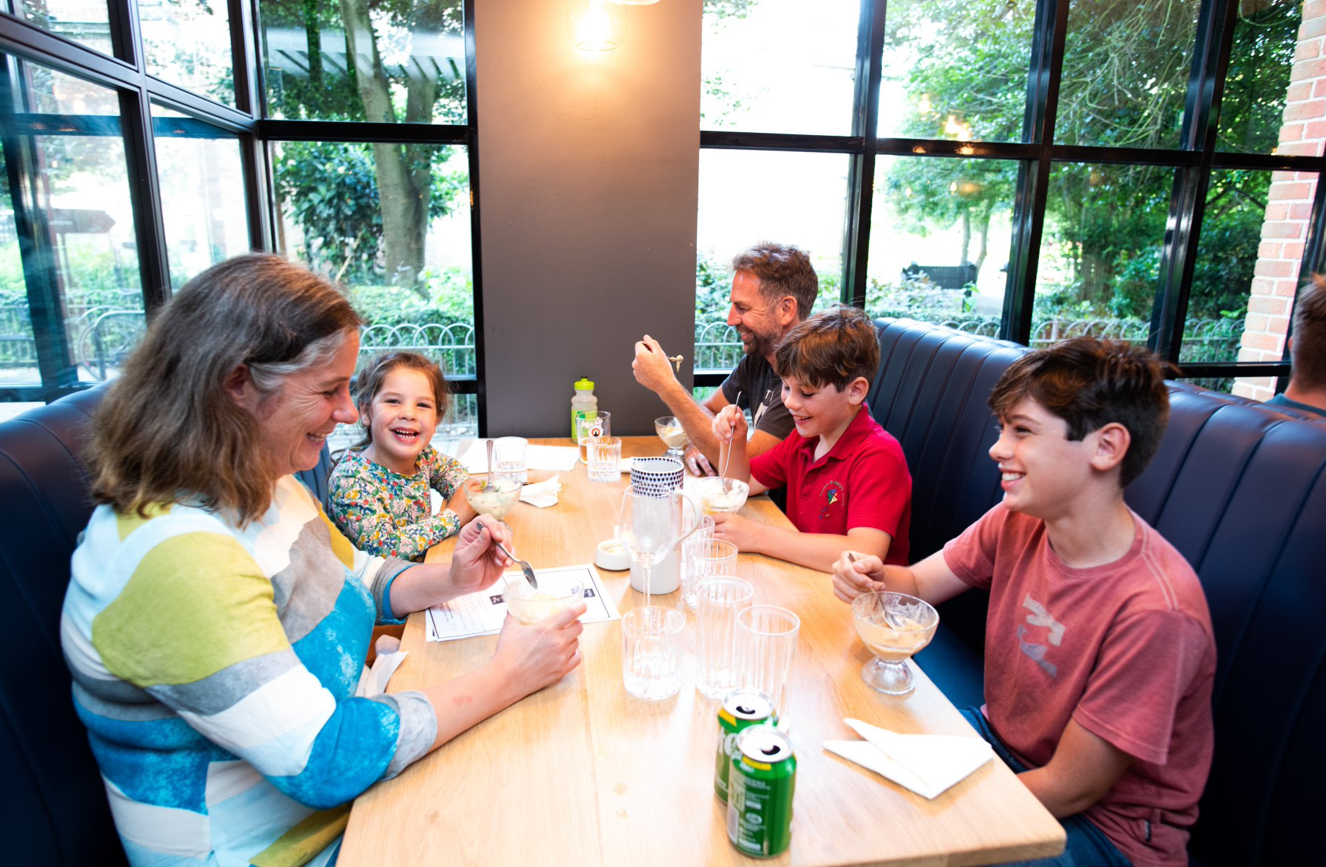 A family is sitting at a table in a restaurant playing cards.