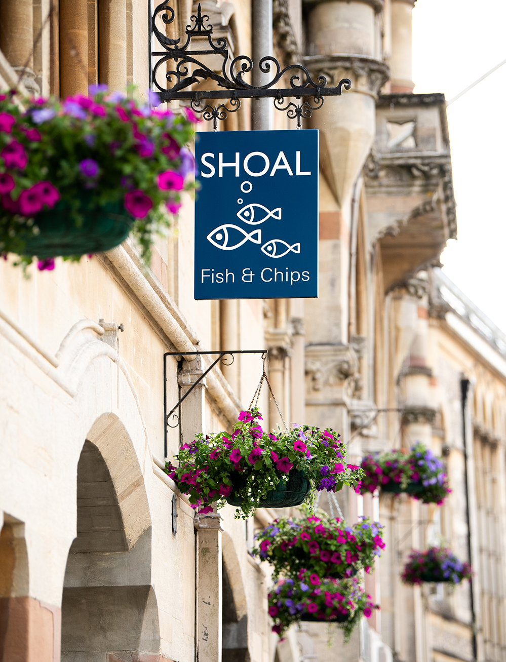A sign for shoal fish and chips hangs on the side of a building