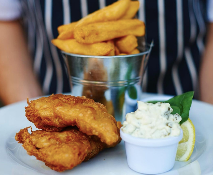 A white plate topped with fried fish and french fries