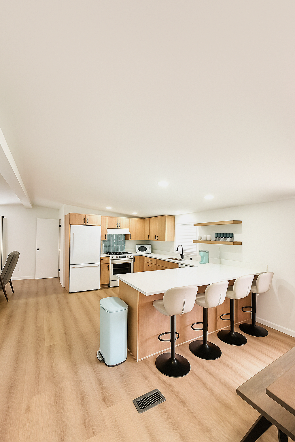 Kitchen with wood cabinets, white countertops, and bar seating.