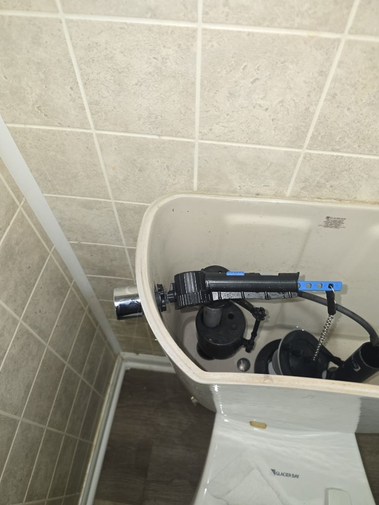 The interior of an open toilet tank shows a makeshift repair using duct tape to secure the flush lever handle.