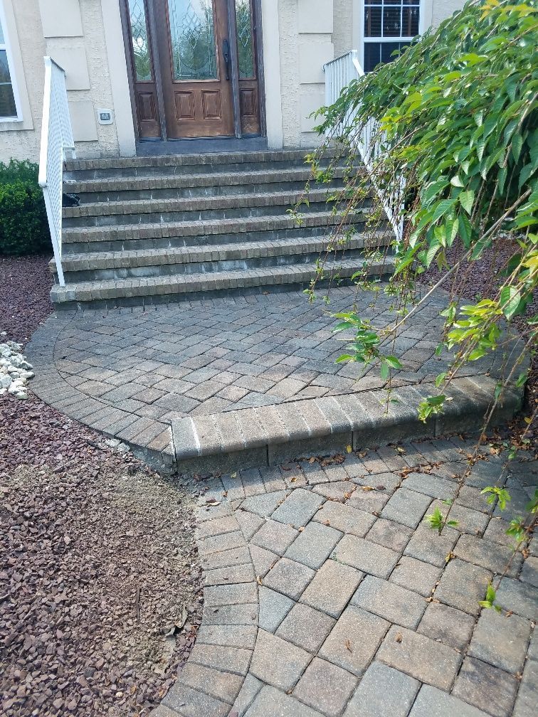 A brick walkway leading to the front door of a house.