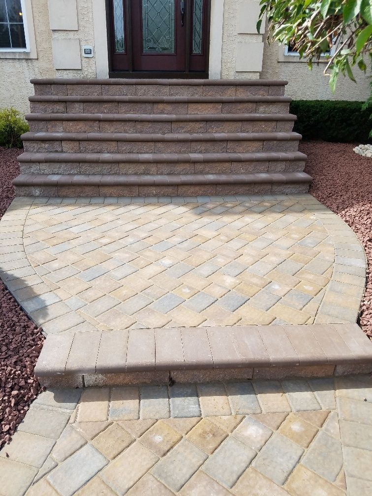 A brick walkway leading to the front door of a house