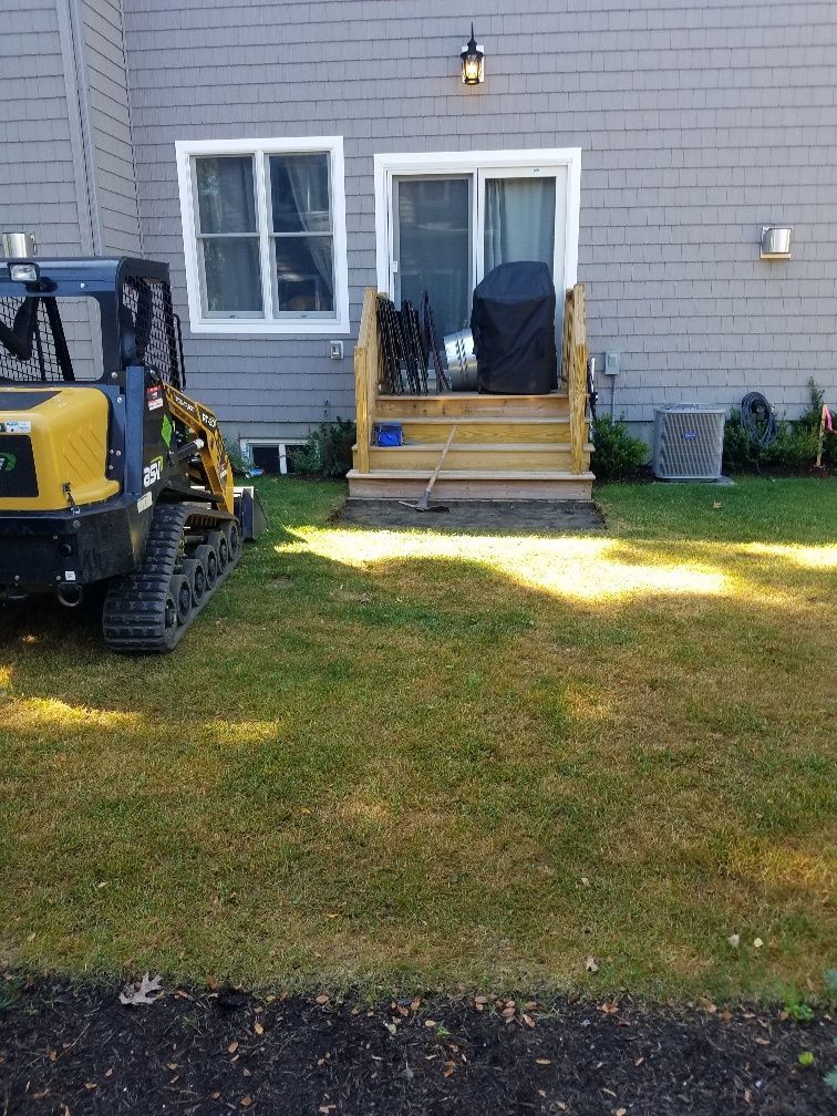 A yellow bulldozer is parked in front of a house.