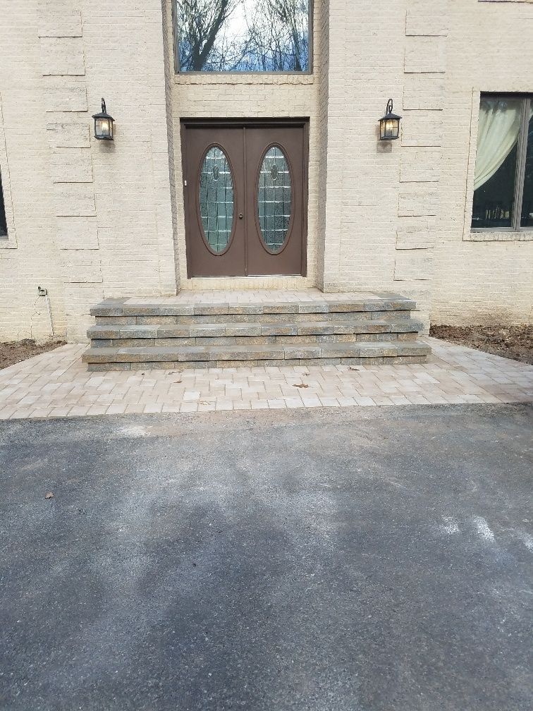 A house with a driveway and steps leading to the front door.