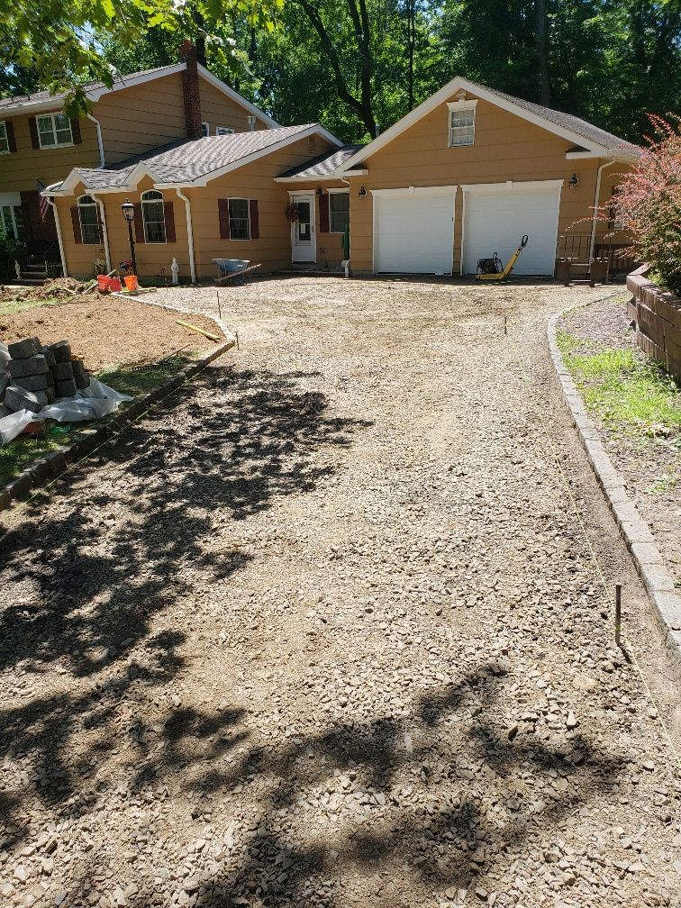 A house with a gravel driveway in front of it.