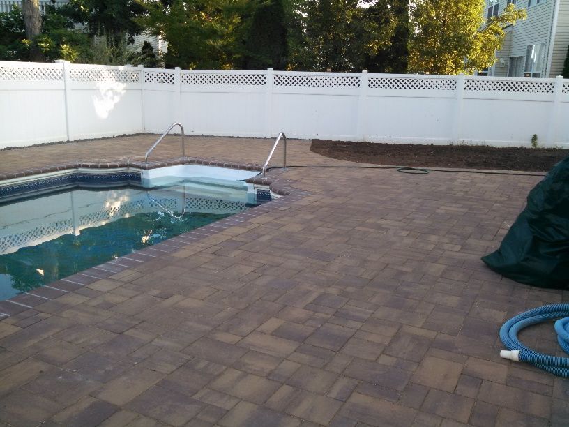 A swimming pool with a white fence surrounding it