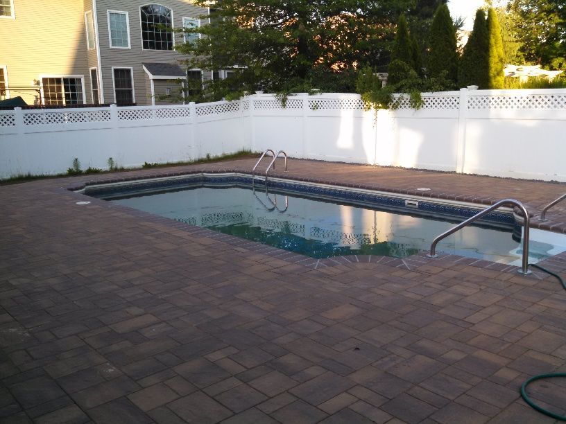 A large swimming pool with a white fence surrounding it