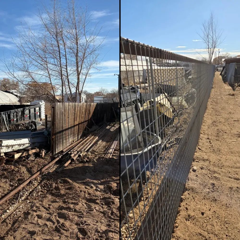 Chain-link fence along a muddy yard beside a leafless tree and a parked truck in winter sunlight