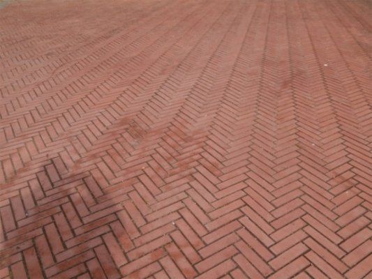 Vista frontale di un pavimento di originale progettazione di diagonali contrapposte di mattoni rossi