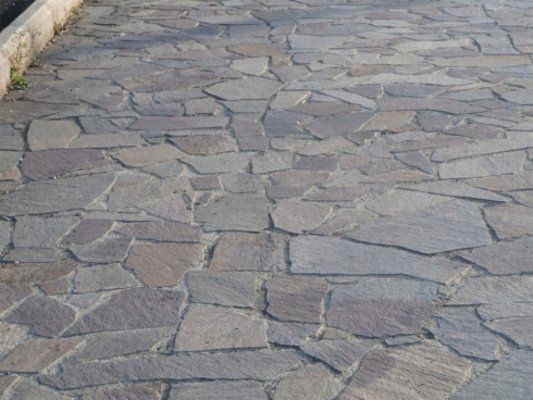 Vista frontale di un pavimento di originale progettazione fatto con lamelle di pietra di diversa forma e dimensioni