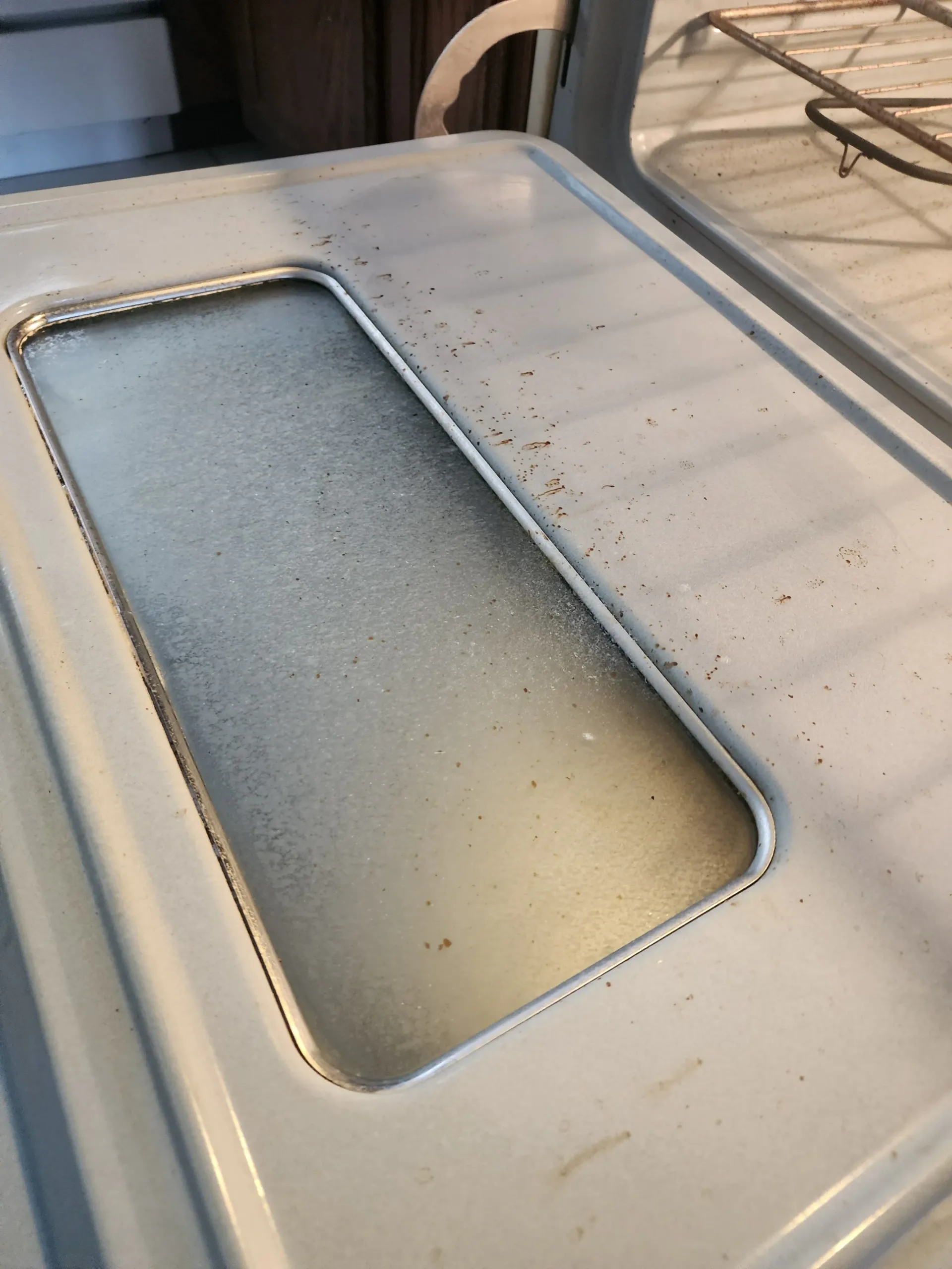 a close up of a dirty oven door with a hole in it