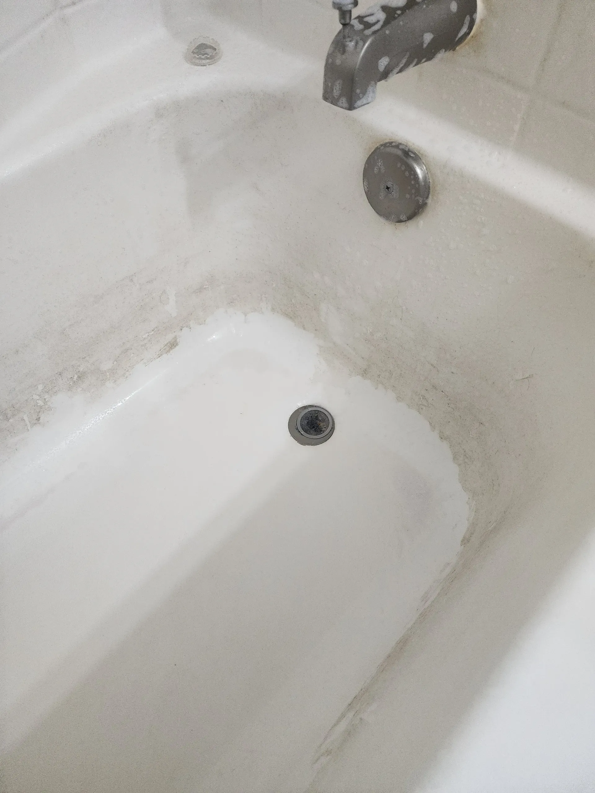 a white bathtub with a faucet on the side of it .