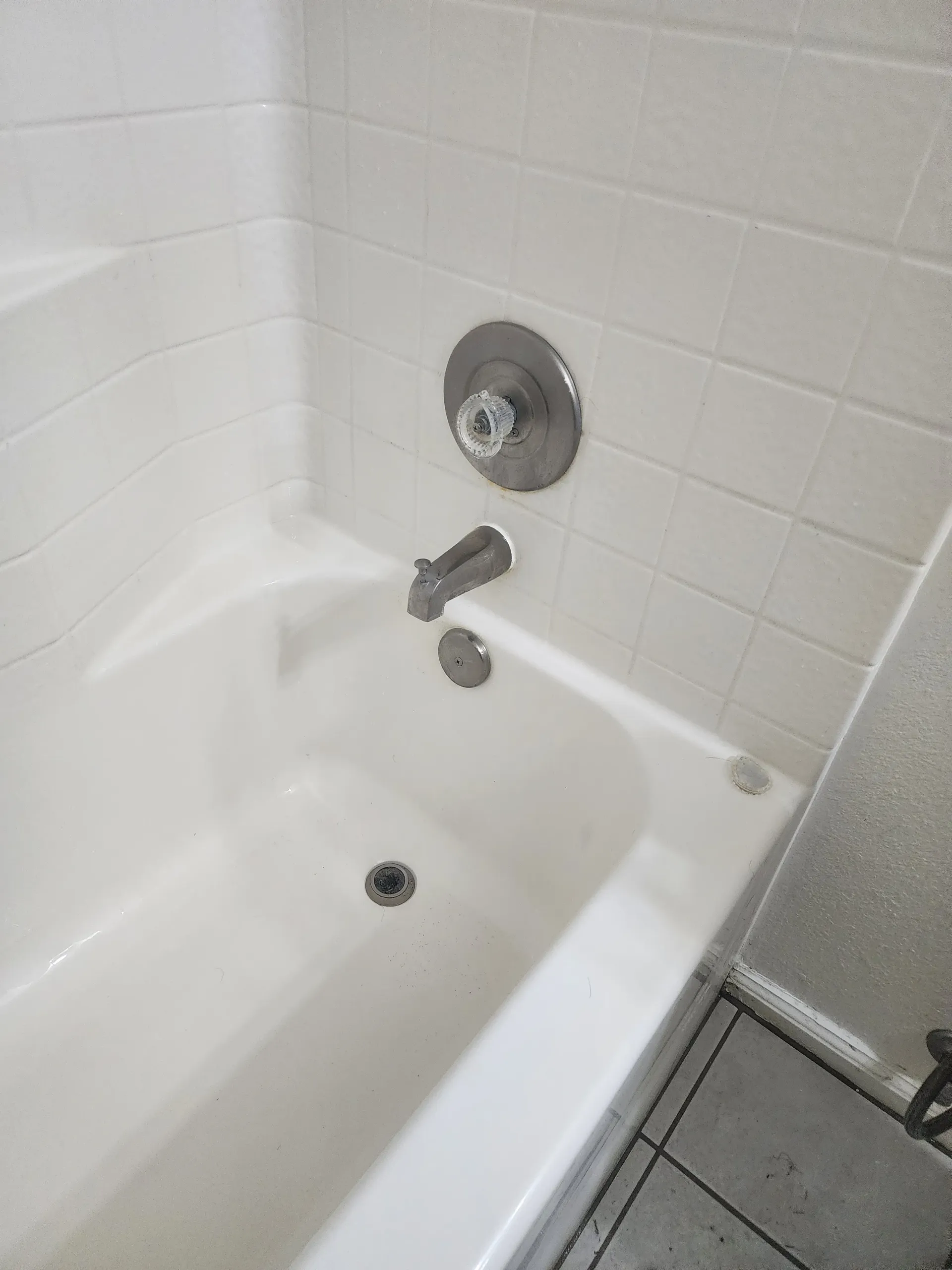 a white bathtub with a chrome faucet in a bathroom .