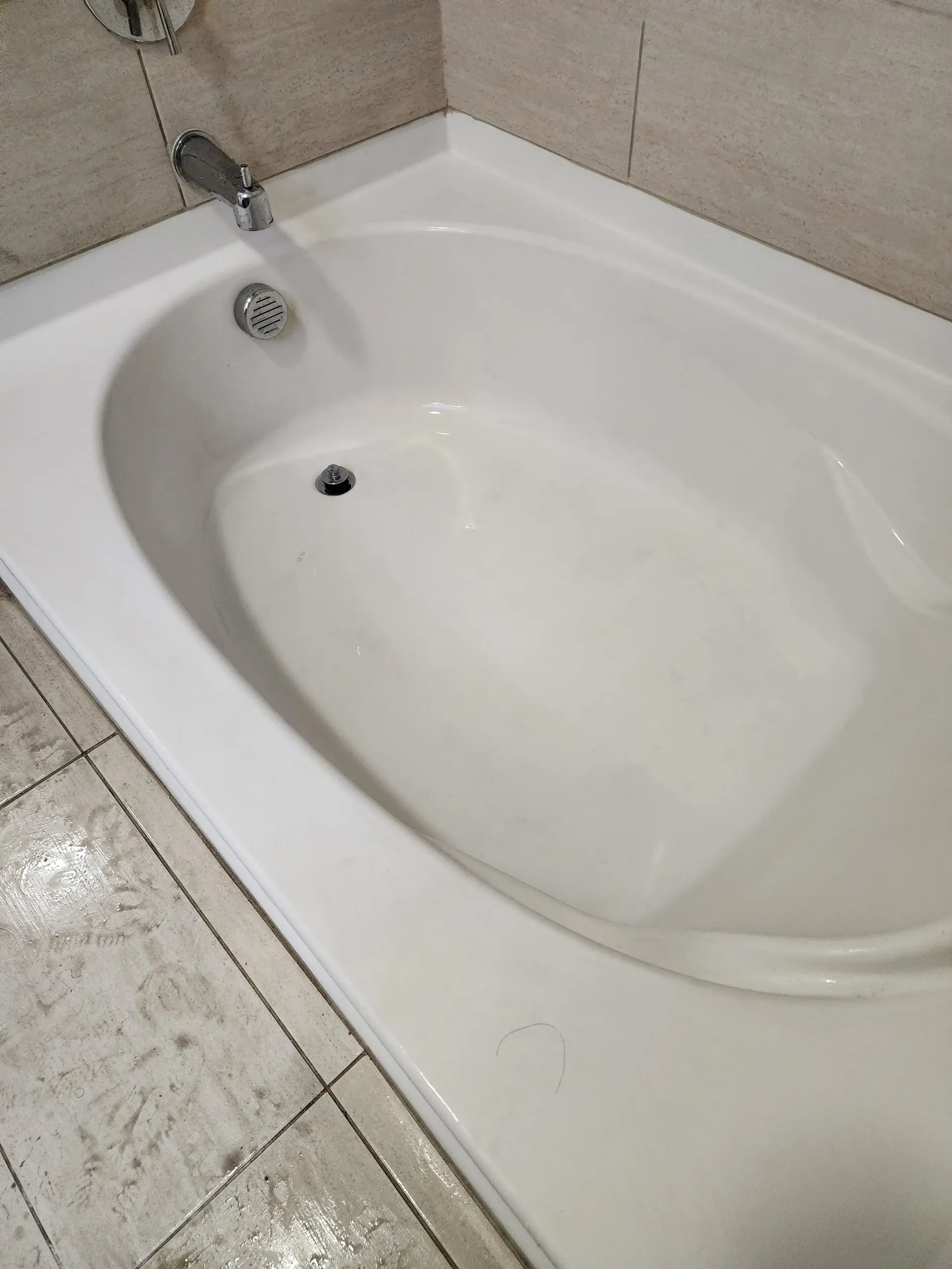 a white bathtub is sitting on a tiled floor in a bathroom .